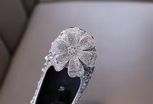Nahaufnahme von glitzernden Strassblumen und Perlendetails an Mädchen-Prinzessinnenschuhen