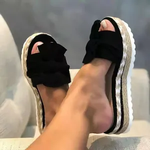 Detail macro view of stylish black bow platform espadrille sandals with woven rope sole