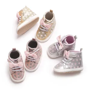 Vue détaillée de jolies chaussures de marche pour bébé avec pois et nœuds