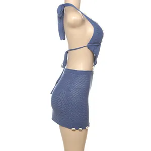 Detail view of blue knitted halter top and mini skirt set with shell beads on mannequin