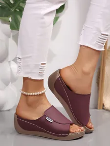 Detailed view of stylish burgundy wedge peep-toe sandals with thick soles and stitching