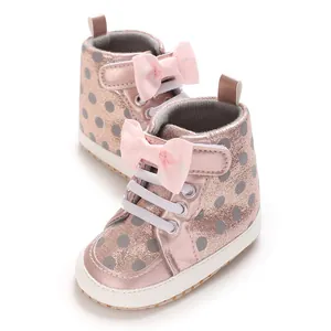 Gros plan de chaussures bébé pailletées roses avec nœud décoratif et motif à pois