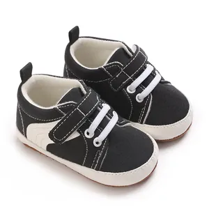 Detailed view of black baby sneakers with white stitching and hook-and-loop straps
