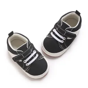 Top view detail of black baby sneakers featuring white stitching and velcro straps