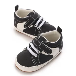 Close-up detail of black and white baby sneakers with velcro straps and soft non-slip soles