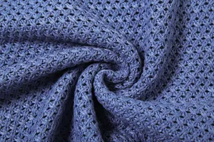 Macro detail of blue hollow-out knitted fabric texture showing intricate weave for dress