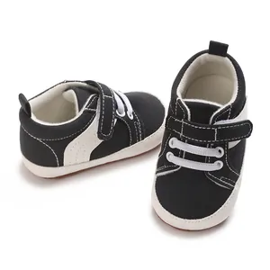 Detailed view of black baby canvas sneakers featuring Velcro strap and soft non-slip soles