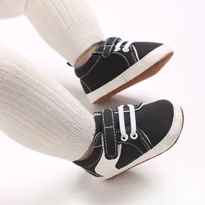 Detailed view of black infant sneakers with secure hook-and-loop straps and soft soles