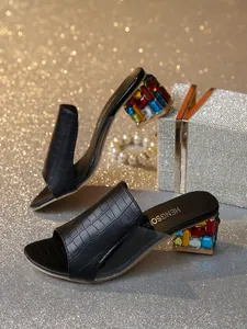Detail der schwarzen Mules mit Krokoprägung und buntem, edelsteinbesetztem Blockabsatz