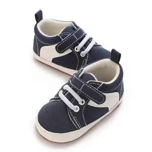 Detailed view of navy canvas baby sneakers with white velcro strap and soft sole