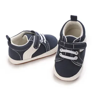 Detailed view of navy blue infant boys' canvas sneakers featuring soft non-slip soles and velcro.