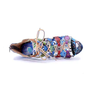 Detailed view of colorful bohemian leather Roman sandals with floral patchwork patterns