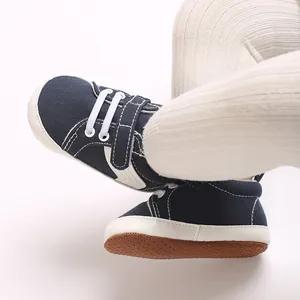 Detail of navy blue canvas baby shoes with soft non-slip soles and white laces
