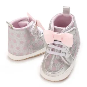 Vue détaillée des chaussures bébé argentées avec pois roses et nœud décoratif