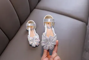 Close-up of sparkling silver girls princess shoe with large rhinestone flower