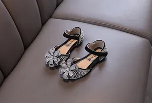 Detailed view of girls' black rhinestone princess shoes with floral accents