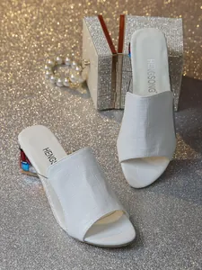 Detail der weißen Maultier-Sandalen mit Krokodilprägung und bunten Kristallabsätzen
