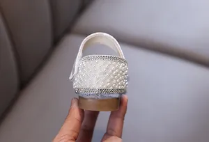 Detail view of silver girls princess shoes with elegant pearl and rhinestone heel