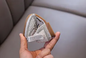Close-up showing the flexible sole of silver girls' princess shoes with pearls and rhinestones