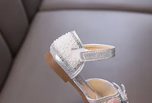 Detail view of silver sparkling girl's princess shoe with pearls and rhinestones