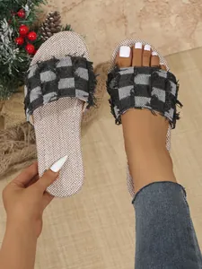 Detailed view of women's checkered denim flat slides featuring trendy frayed edge straps