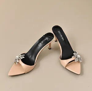Detailansicht beige spitze Mules mit funkelnden, eleganten Kristallblumen-Verzierungen