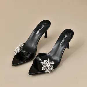 Elegante schwarze Mules mit spitzer Zehenpartie und funkelndem Strass-Schneeflocken-Dekor.