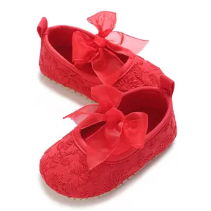 Nahaufnahme von roten bestickten Babyschuhen mit dekorativen großen Schleifen für Mädchen