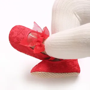 Nahaufnahme von roten bestickten Babyschuhen mit großem Schleifendetail