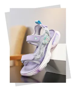 Gros plan de sandale violette pour fille avec détail papillon et accents pailletés argentés.
