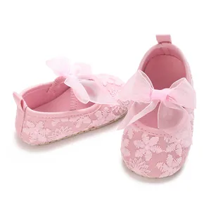 Nahaufnahme von rosa Babyschuhen mit zarter Blumenstickerei und Schleifen für Mädchen