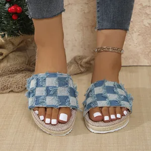 Close-up of denim checkerboard flat slippers with frayed edges and jute sole