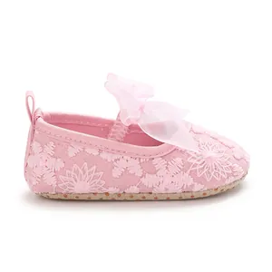 Detailansicht von rosa Babyschuhen mit zarter Blumenstickerei und Organzaschleife