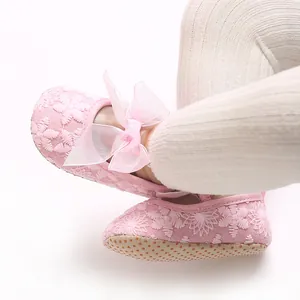 Weiche rosa Babyschuhe für Mädchen mit feiner Spitzenstickerei und zarter Schleife