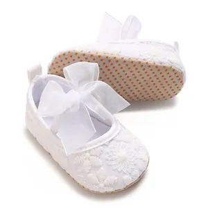 Detailansicht von weißen Babyschuhen für Mädchen mit floraler Spitze und Schleife
