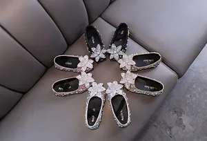 Detailed top view of sparkling girls' princess shoes with rhinestone flowers and pearls