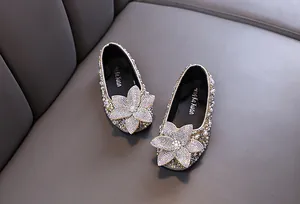 Detailed macro view of girls' sparkling rhinestone princess shoes with pearl trim