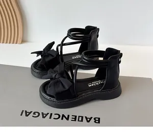 Vue détaillée des sandales romaines noires pour filles avec nœud élégant et semelle souple