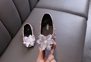 Close-up of pink sparkling rhinestone princess shoes for girls with flower detail