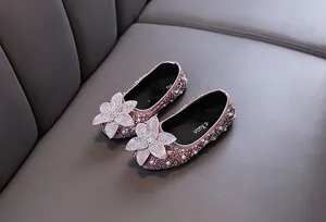 Close-up view of elegant pink girls princess shoes with rhinestones and flower detail.