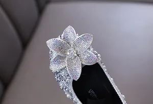 Macro detail showing the sparkly rhinestone flower on girls silver princess dress shoe