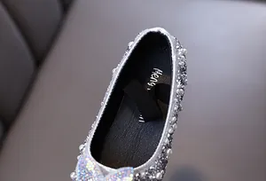Close-up detail of silver glitter girl princess shoes with sparkling pearls and rhinestones