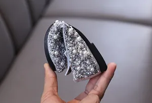 Detailed view of flexible silver girl's princess shoes with pearls and rhinestones