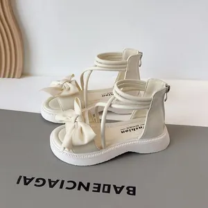 Sandales romaines crème pour filles avec nœud décoratif et brides croisées pour l'été