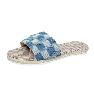 Close-up of blue checkered denim flat slipper featuring stylish frayed edges and woven sole