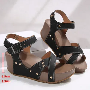 Detailaufnahme von schwarzen Plateausandalen mit Nieten und einer Absatzhöhe von 6,5 cm