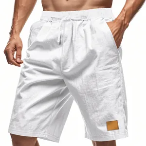 Dettaglio dei pantaloncini in lino bianco traspirante con coulisse e toppa decorativa.
