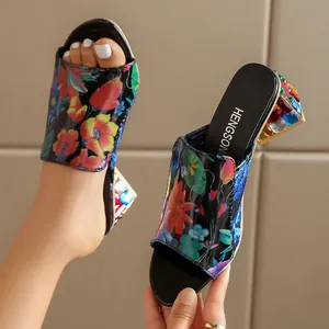 Detalle de mules florales para mujer con tacones anchos de pedrería multicolor