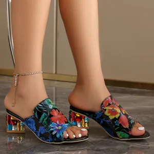 Detalle de sandalias de tacón ancho con estampado floral y pedrería de colores mujer