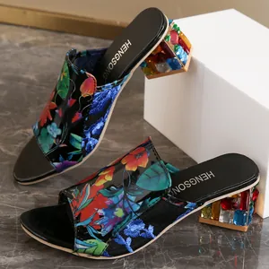 Detalle de los mules con estampado floral y tacones anchos de pedrería multicolor.